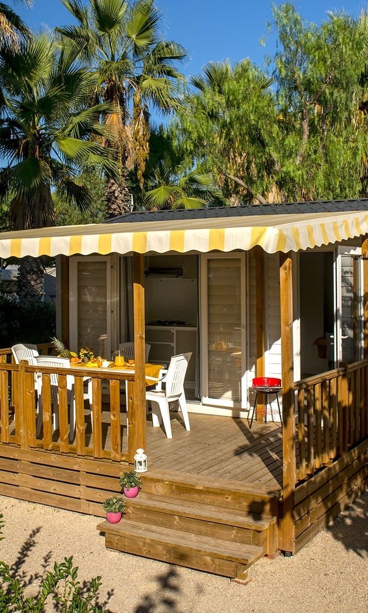 una pequeña casa con una mesa y sillas en el porche