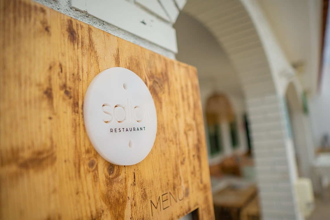 una tabla de madera con el logotipo del restaurante solo