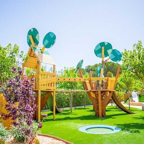 un área de juegos en forma de árbol con un trampolín