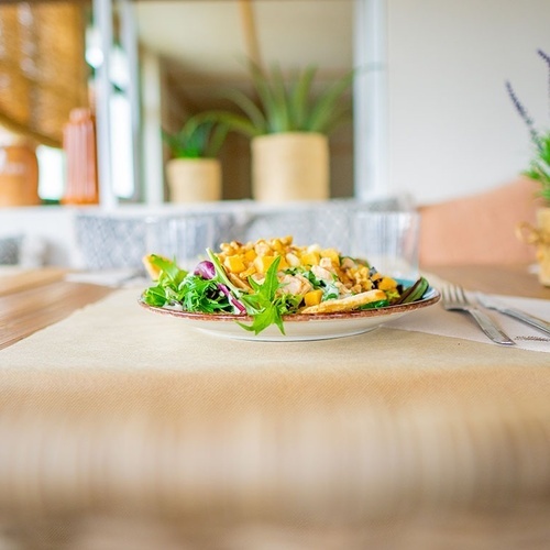 un plato de ensalada está sobre una mesa de madera