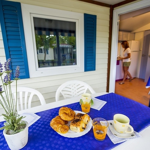 una mesa con un plato de croissants y un vaso de jugo de naranja