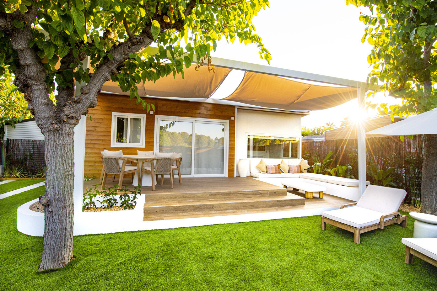 Terrasse d'hôtel avec coin salon extérieur, transats et vue sur le jardin, idéale pour se détendre Creixell camping & family resort.