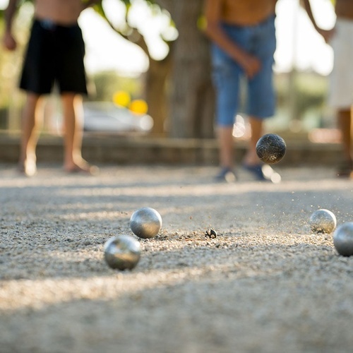 un grupo de niños están jugando a la petanca