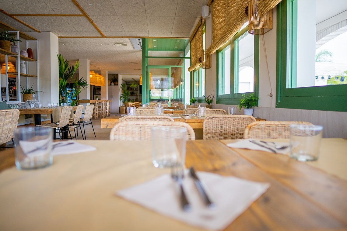 un restaurante vacío con mesas y sillas de mimbre