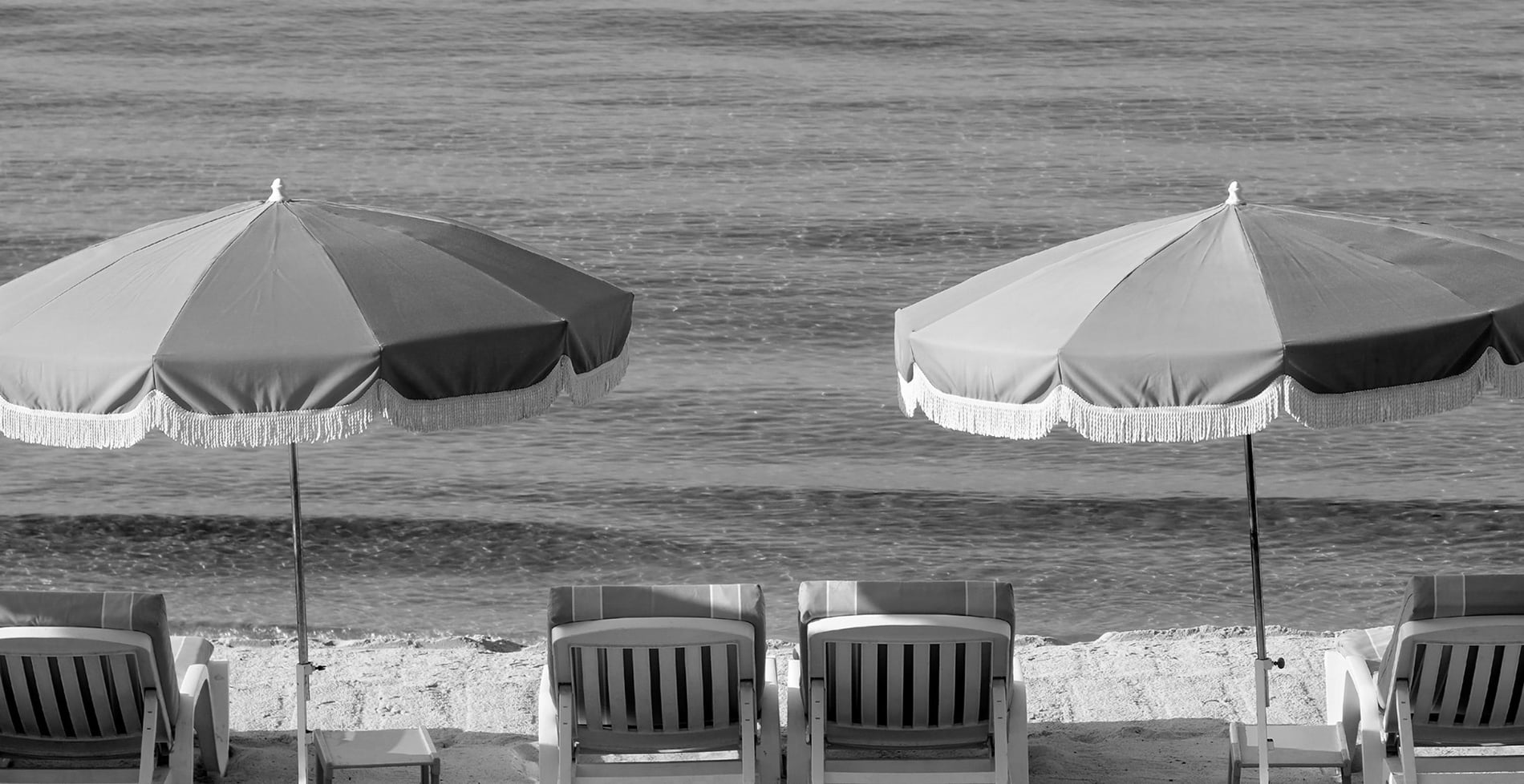 sillas y sombrillas en la playa frente al océano=s1900