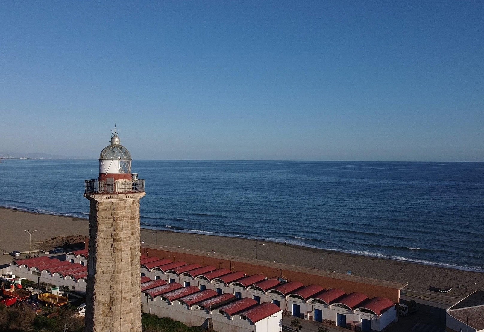 un faro se encuentra en la playa junto al océano