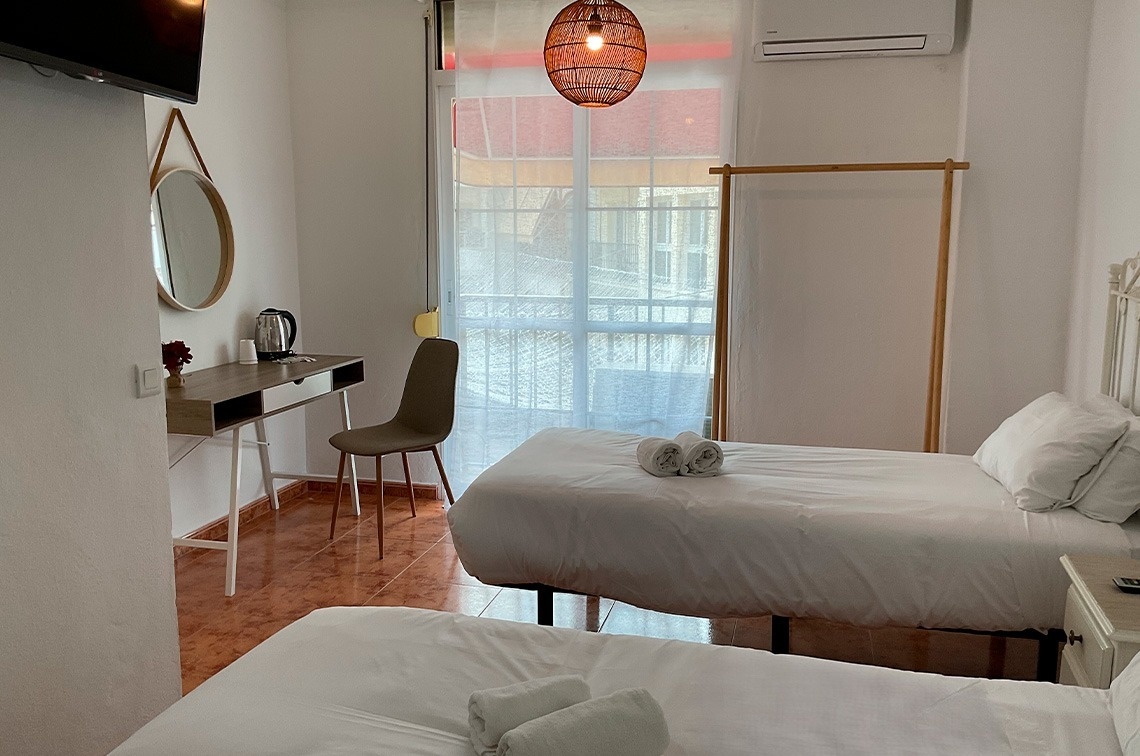 una habitación con dos camas , un escritorio y una televisión