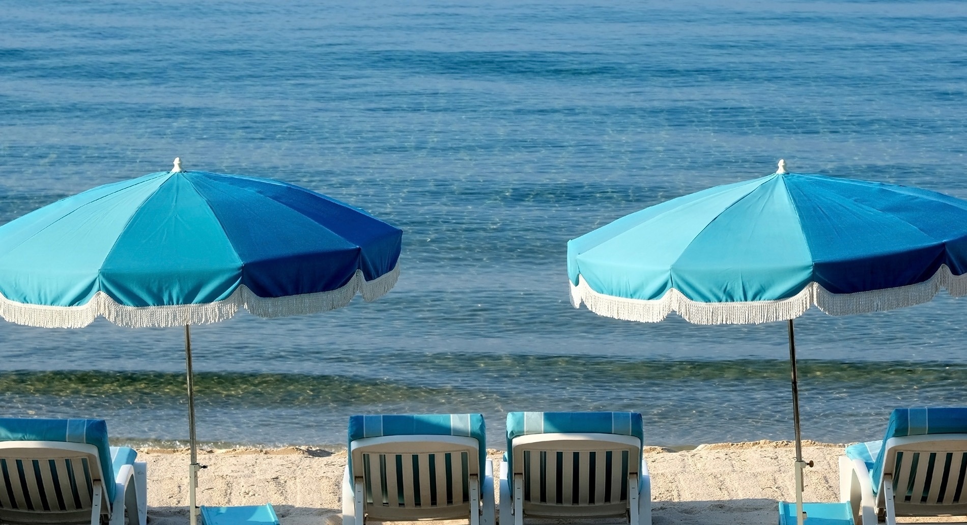 una playa vacía con el océano en el fondo