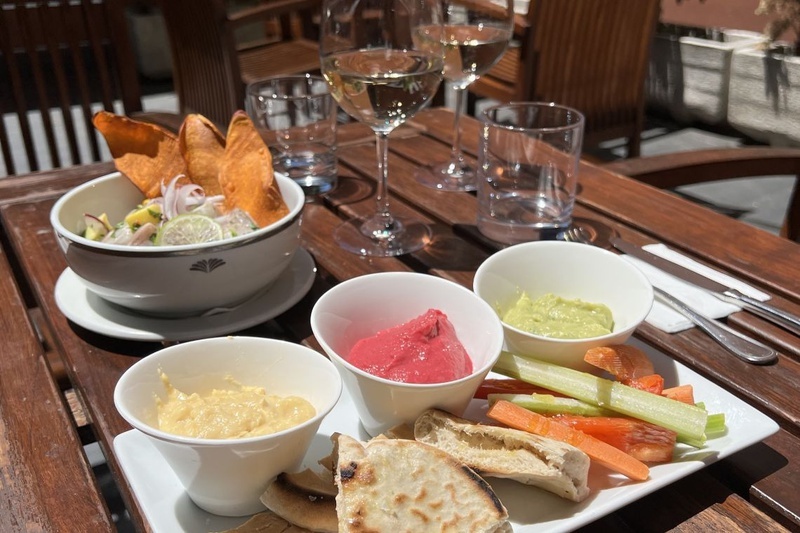 una mesa de madera con platos de comida y copas de vino
