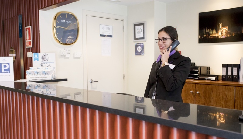 una mujer habla por teléfono en la recepción de un hotel