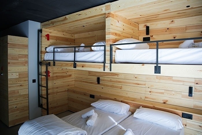 una habitación de madera con literas y una escalera