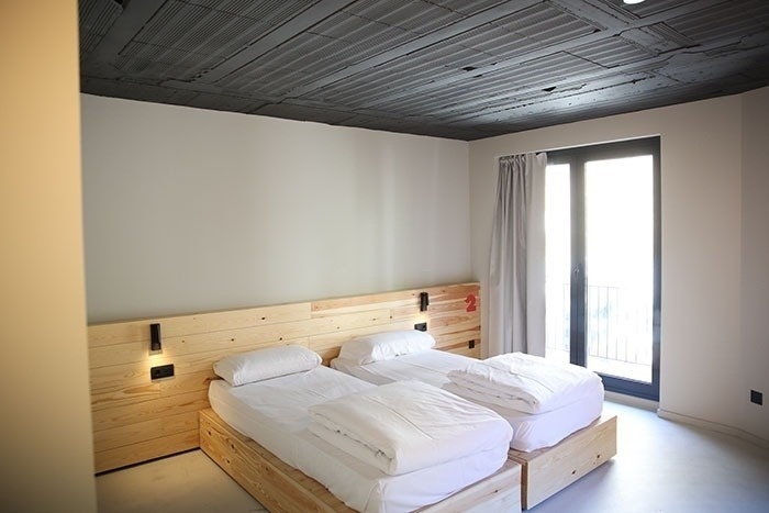 una habitación con dos camas y una ventana con el número 2 en la pared