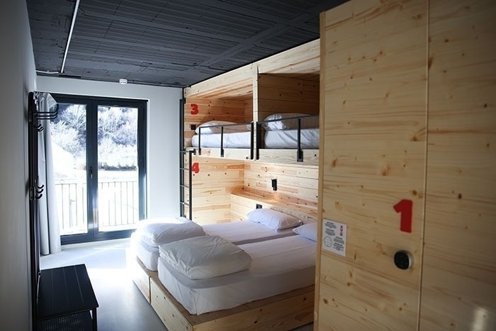 una habitación con literas de madera y una puerta de madera con el número 1