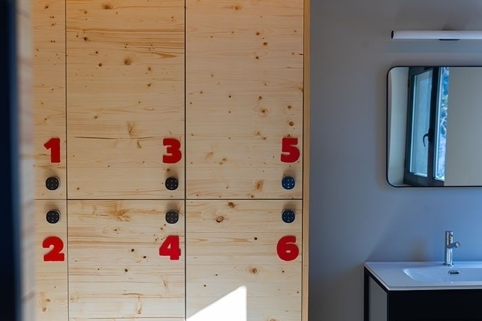 un armario de madera con los números 1 2 3 4 5 6 pintados en rojo