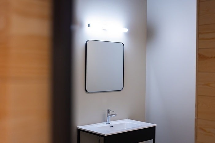un baño con lavabo y espejo en la pared