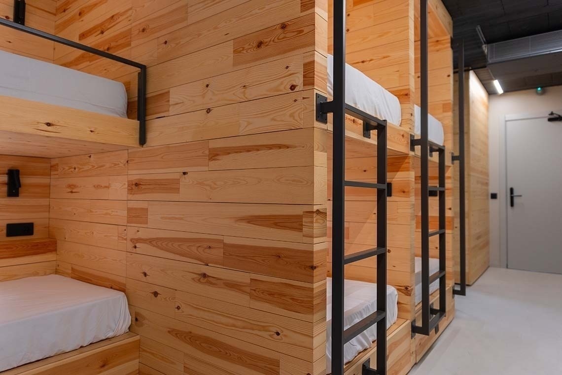 una fila de literas de madera con escaleras en una habitación