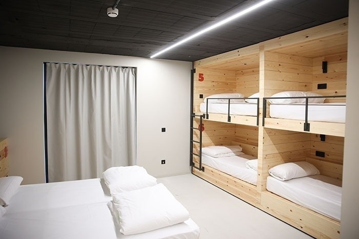 una habitación con literas de madera y la letra 5 en el techo