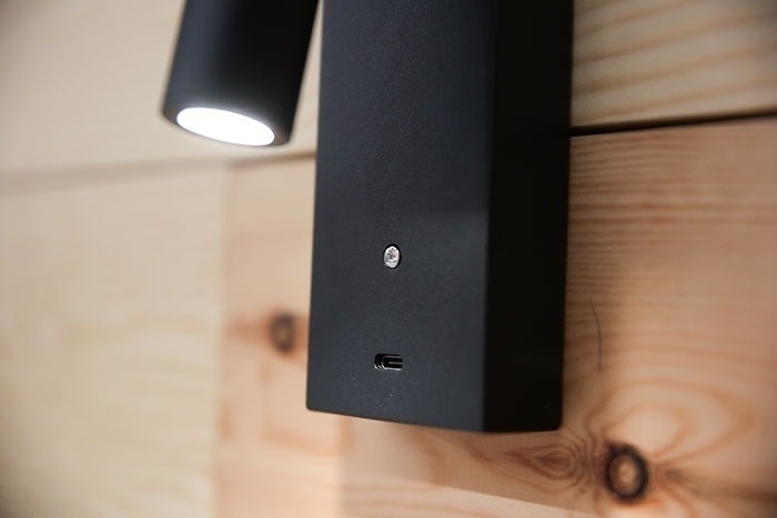 un primer plano de una lámpara negra en una pared de madera