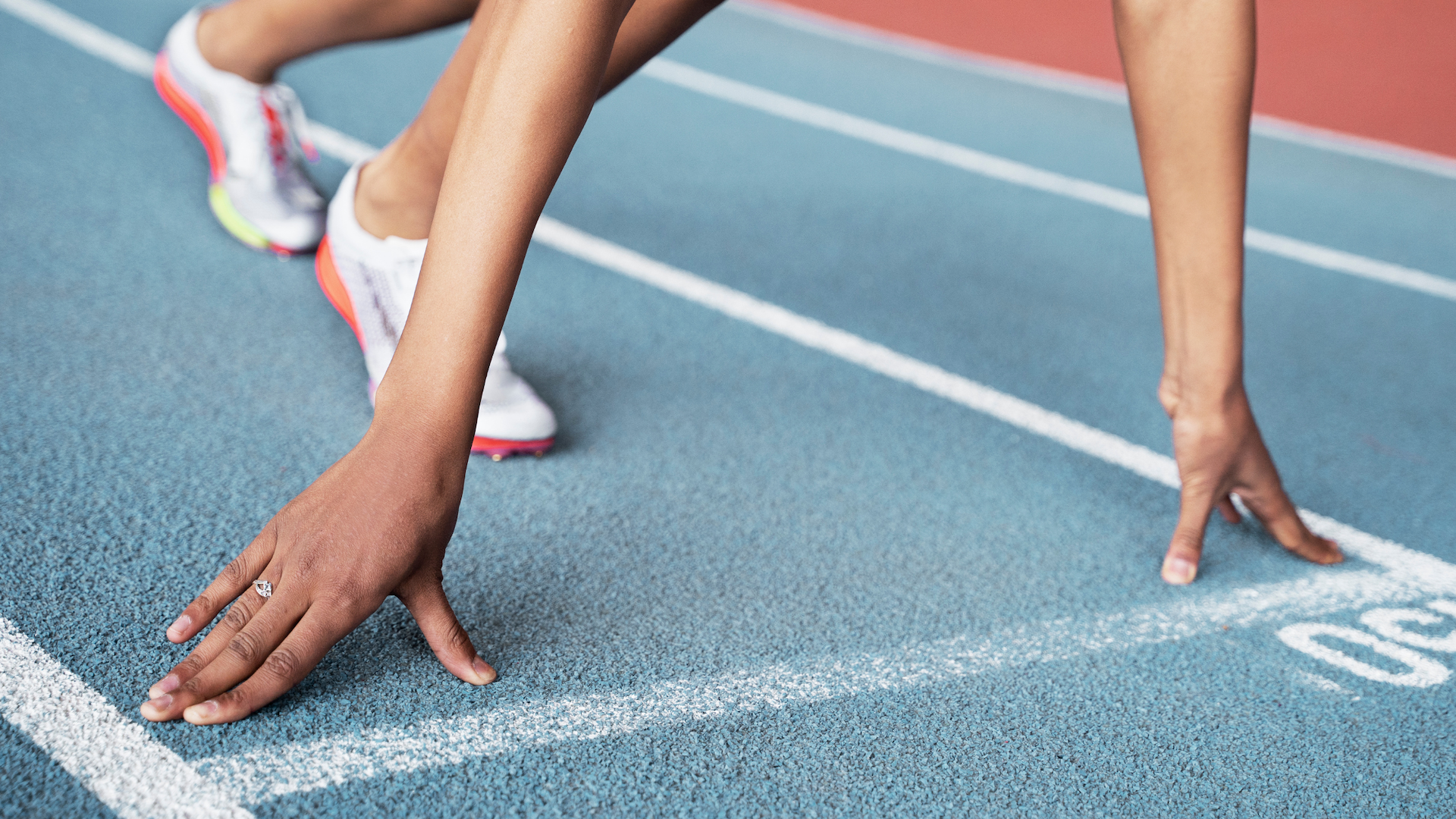 un atleta se prepara para iniciar una carrera en una pista de atletismo