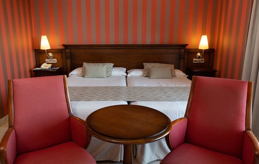 una habitación de hotel con dos camas y una mesa