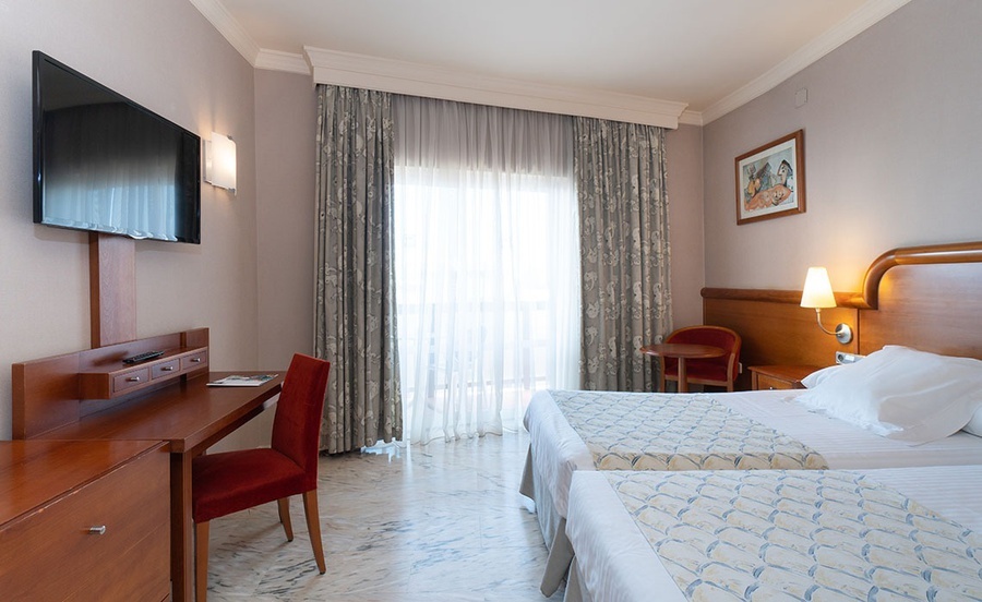 una habitación de hotel con dos camas y una televisión