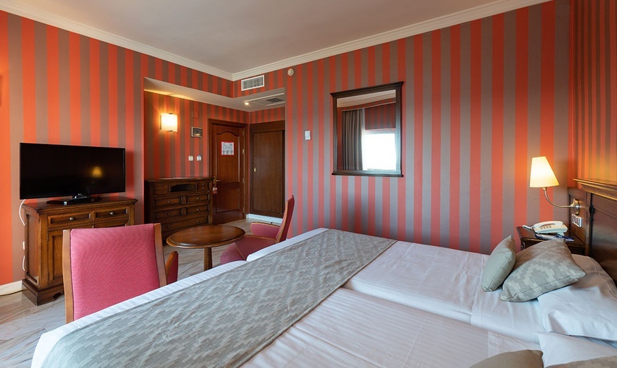 una habitación de hotel con dos camas y una televisión