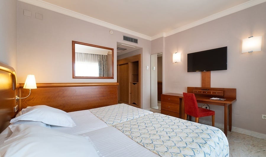 una habitación de hotel con dos camas y una televisión