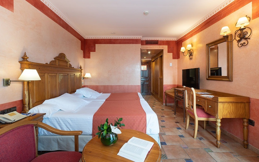 una habitación de hotel con dos camas y un escritorio