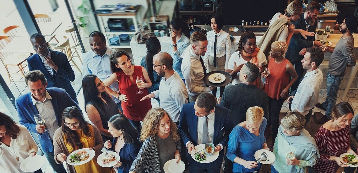 um grande grupo de pessoas está comendo comida em uma festa