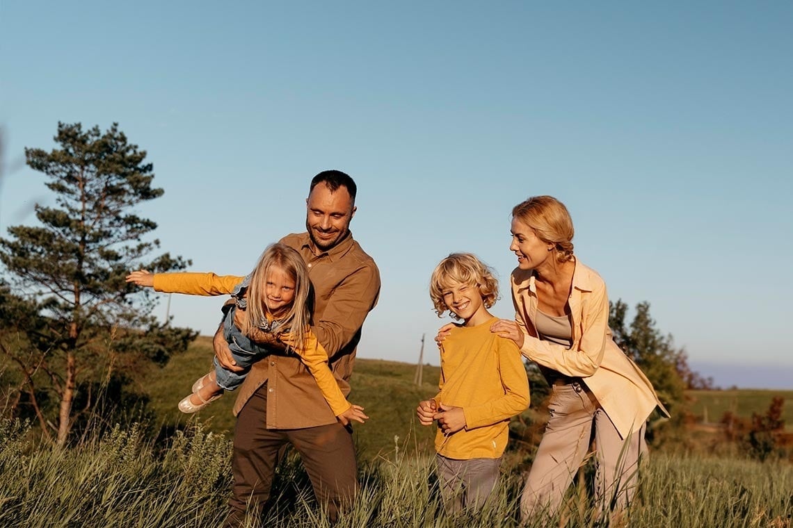 una famiglia è in piedi in un campo di erba alta