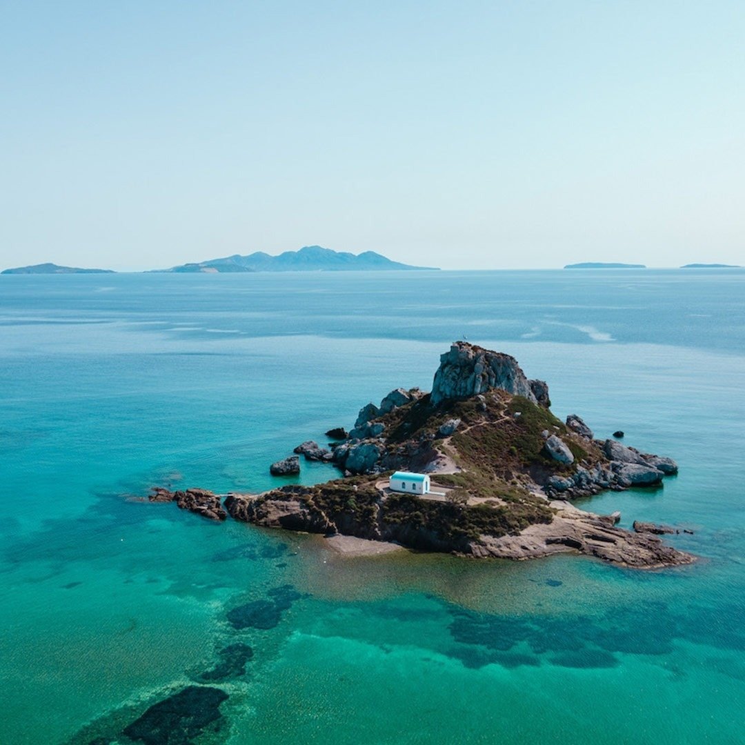 una piccola isola in mezzo all'oceano con una chiesa bianca