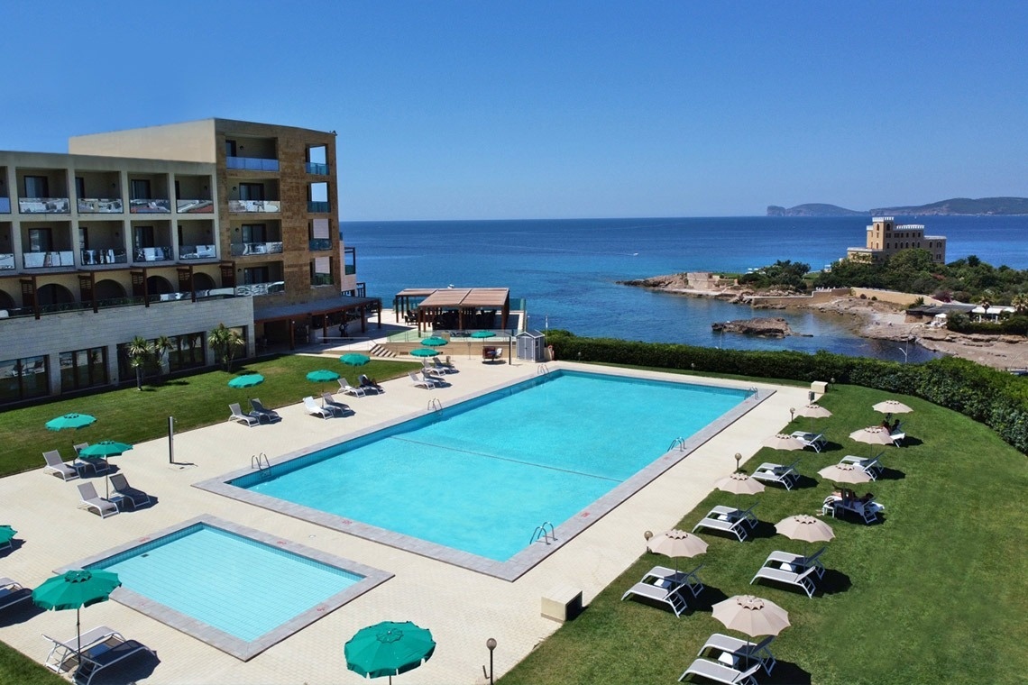 una grande piscina circondata da sedie e ombrelloni