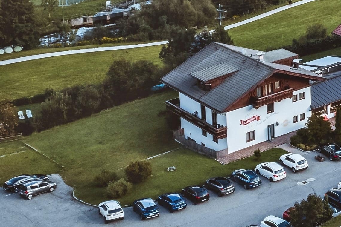 un grande edificio bianco è circondato da auto parcheggiate