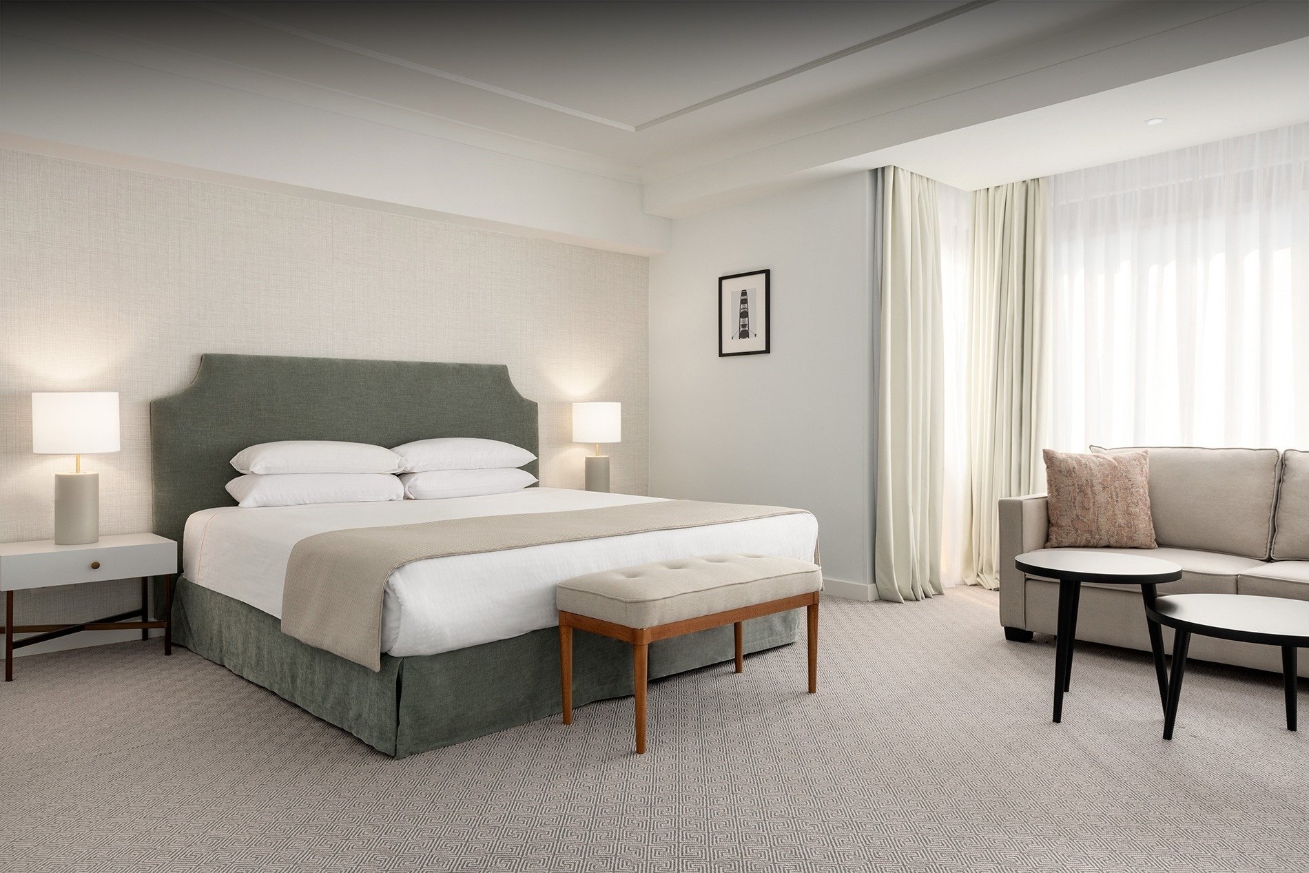 um quarto de hotel com cama king size e sofá