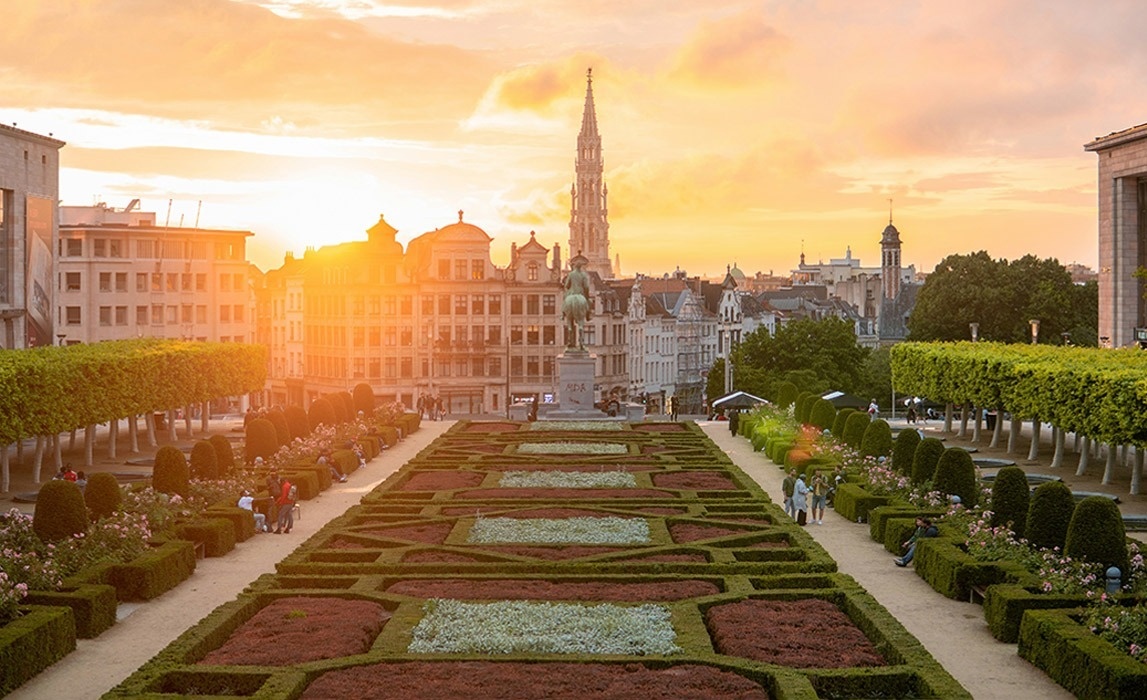 a beach with palm trees and a red building in the background