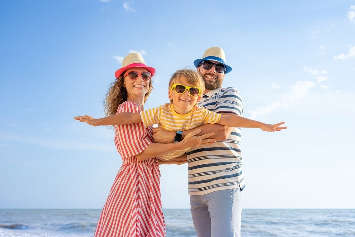 a family is posing for a picture on the beach