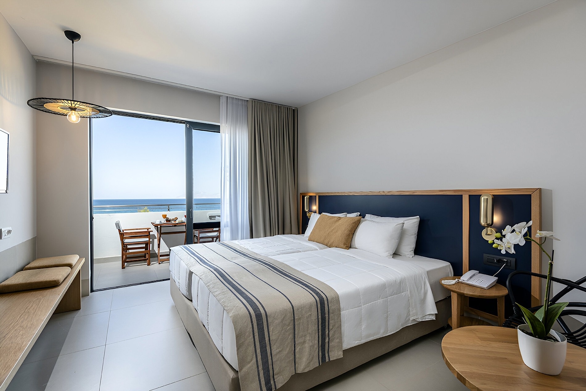 um quarto com cama e mesa com vista para o oceano