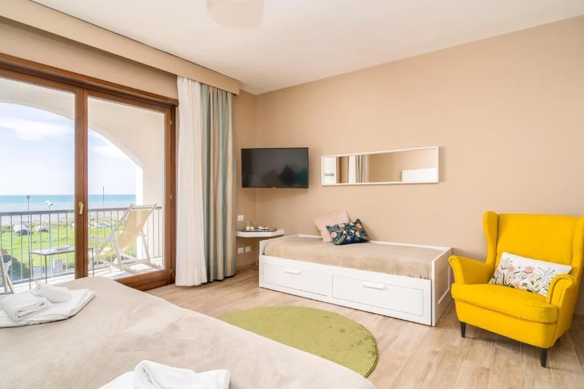 ein Schlafzimmer mit einem Bett und einem gelben Stuhl