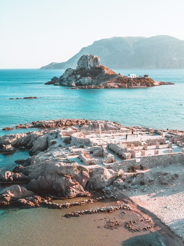 eine Gruppe von Menschen steht auf einer kleinen Insel im Ozean