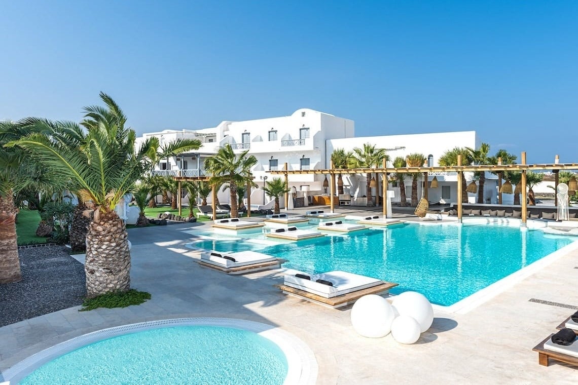 ein Hotel mit einem großen Swimmingpool und weißen Betten