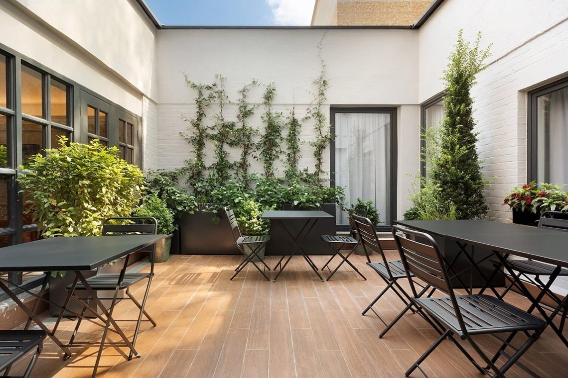 un patio con tavoli e sedie e una finestra