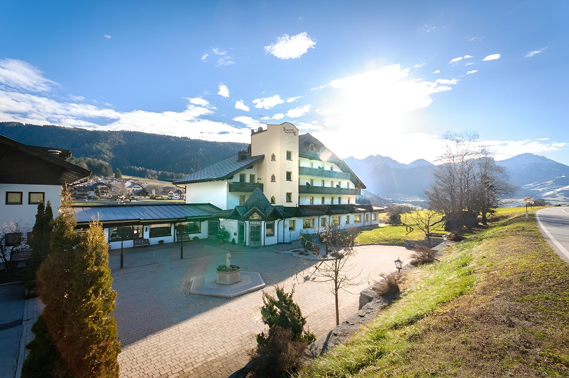 un grand bâtiment blanc avec une fontaine à l' extérieur