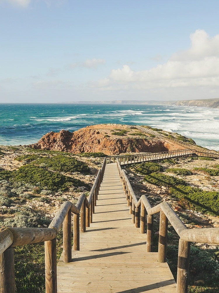 eine Holztreppe führt zum Ozean