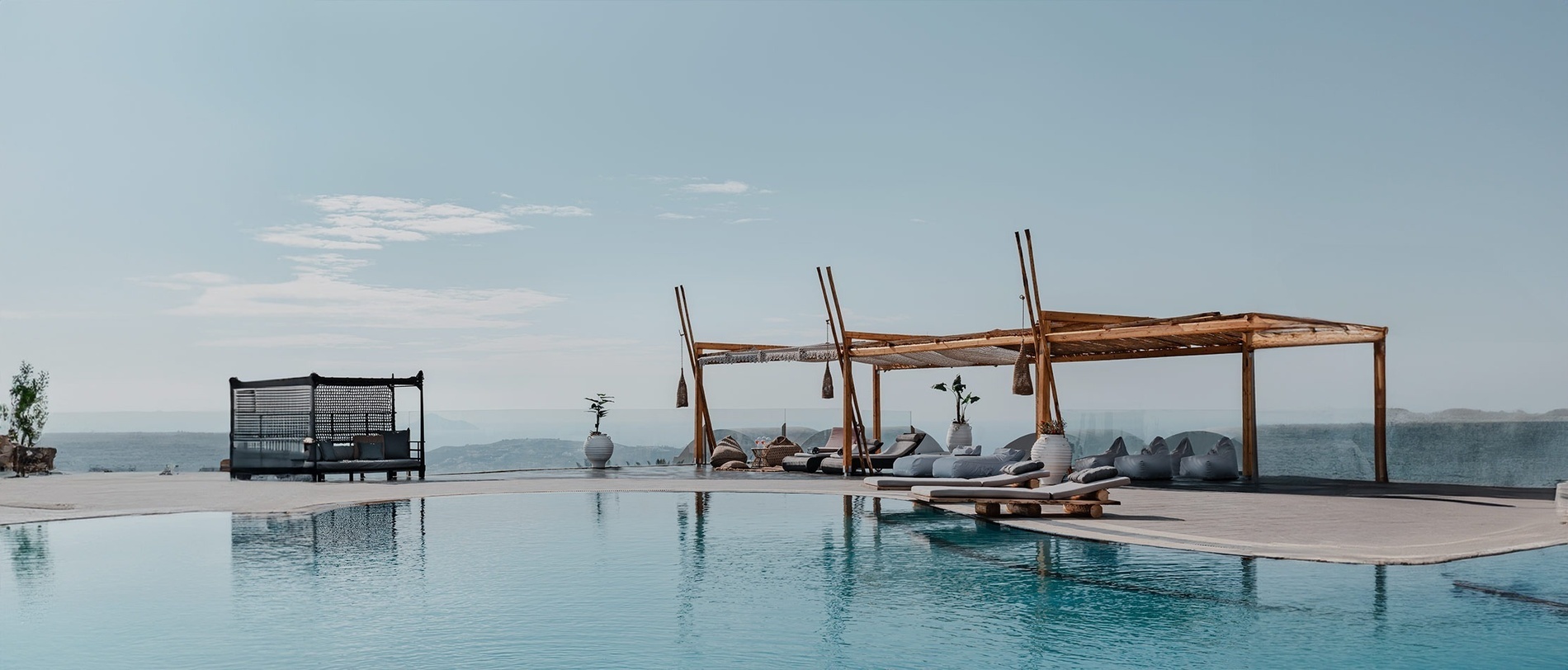 una casa se refleja en una piscina con montañas en el fondo