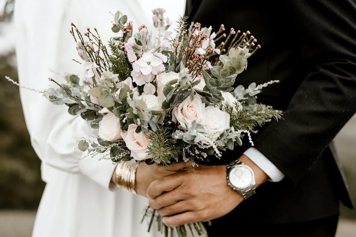 a glass of red liquid with a straw on the beach