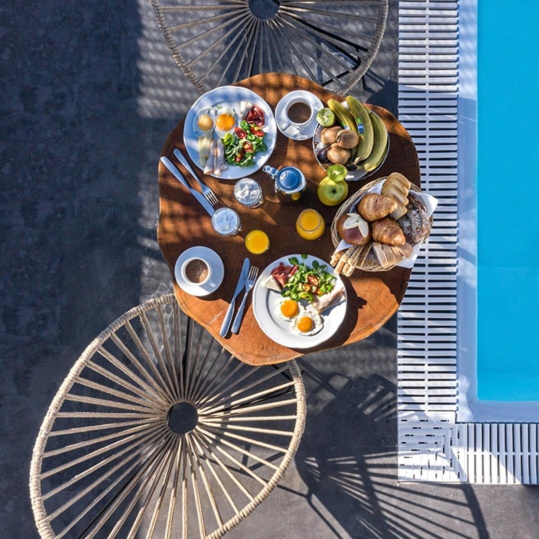 un tavolo con piatti di cibo e bevande accanto a una piscina