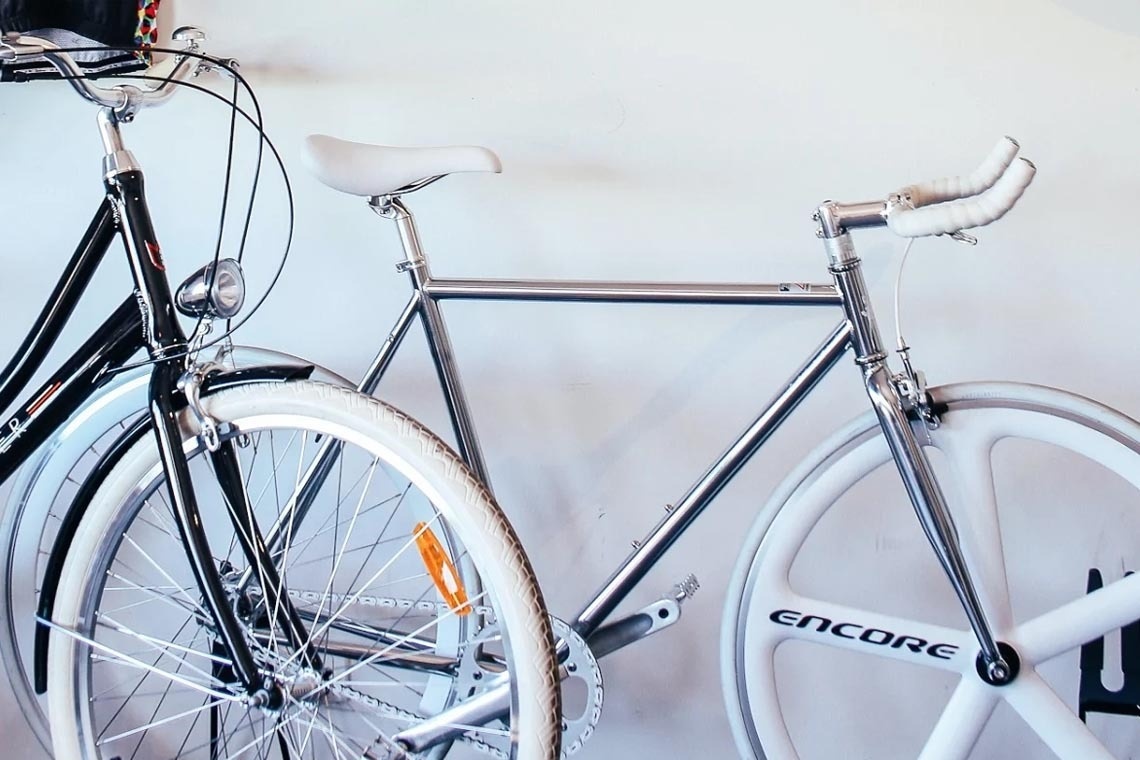 una bicicletta è appesa a un muro accanto a una bicicletta nera