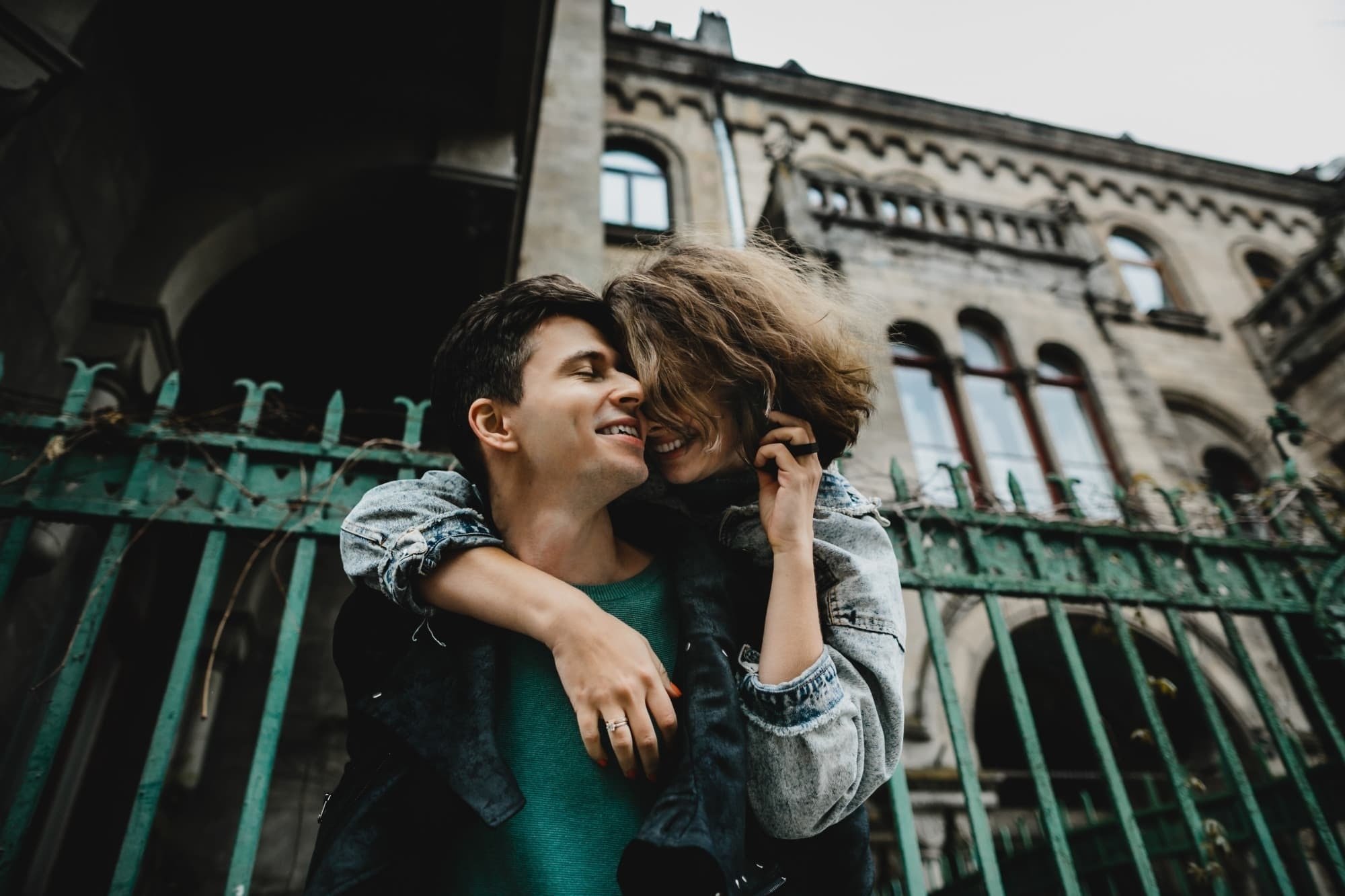 ein Mann und eine Frau umarmen sich vor einem Gebäude