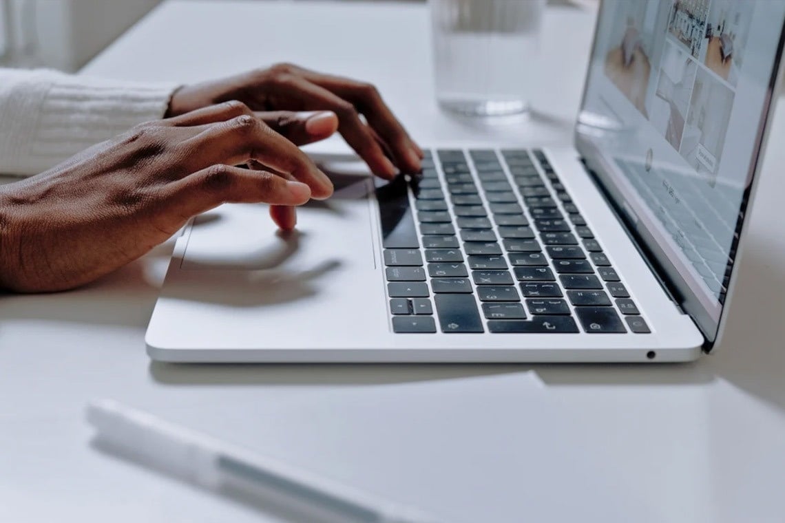 une personne tapant sur un ordinateur portable avec le clavier visible