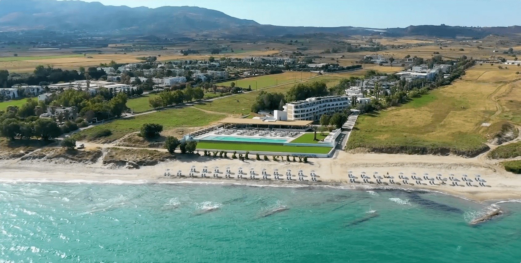 una vista aérea de una playa con un hotel en el fondo